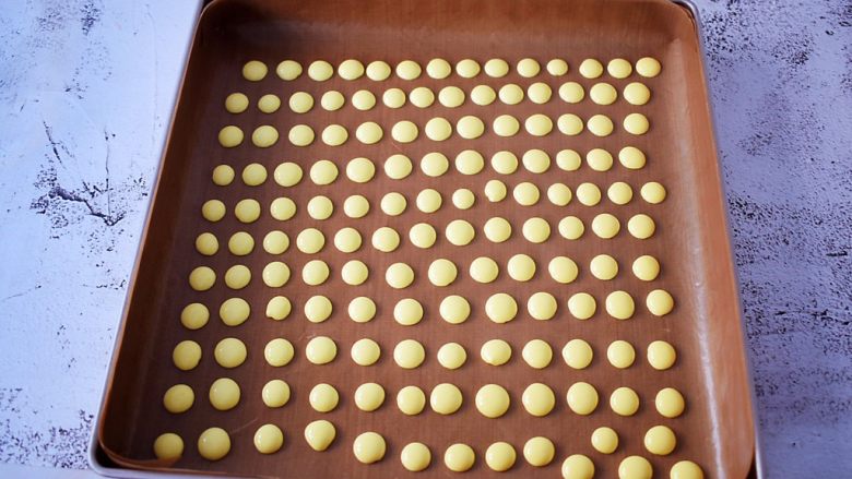 蛋黄溶豆,烤盘垫上耐高温油布或者油纸，再挤入烤盘中