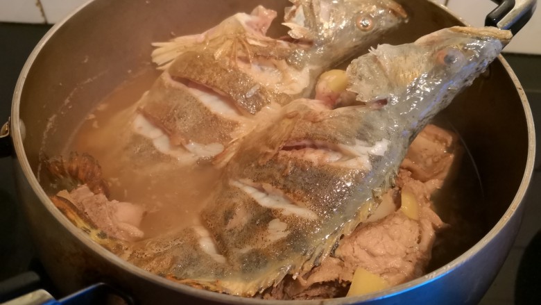 排骨鳜鱼粉皮煲,另一面也煎定型后，倒入排骨锅中。
