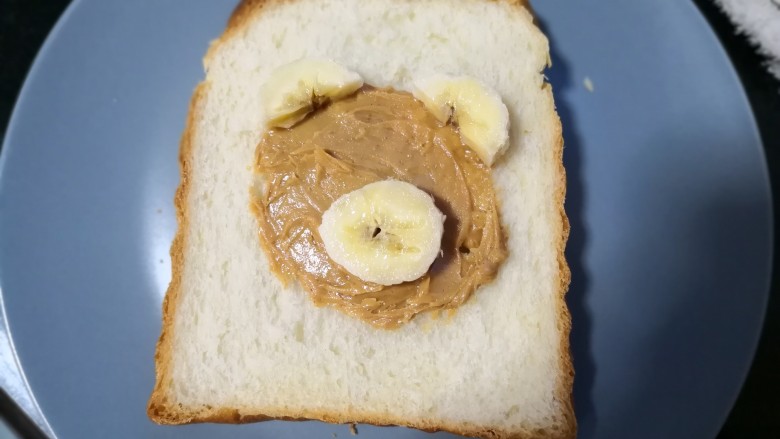 可爱早餐之维尼熊吐司,取一片香蕉切成两半，做耳朵。再取一片做眼睛。