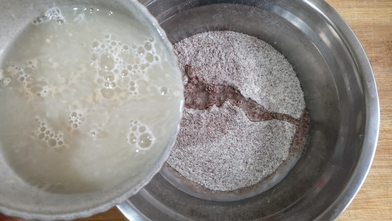 卡通龙猫豆沙包,将酵母粉用温水冲开，少量多次加入黑全麦粉中。