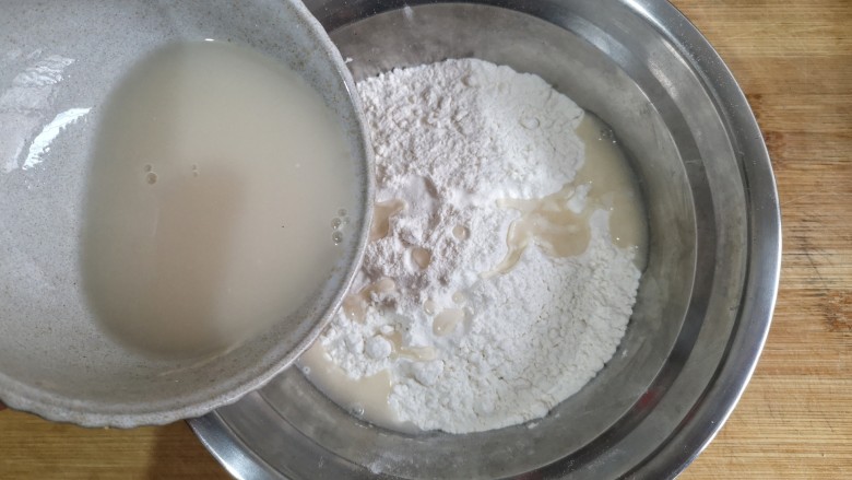 卡通龙猫豆沙包,将酵母粉用温水冲开，少量多次加入白面粉中。