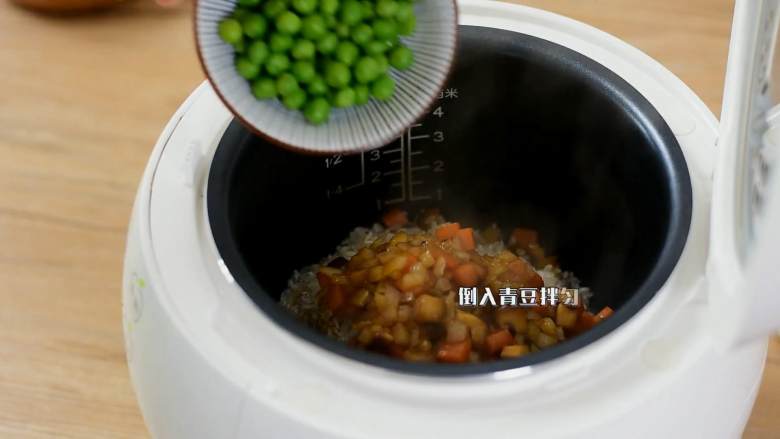 电饭煲懒人饭，还没出锅已经满屋子香味了,电饭煲倒入淘净的大米和煸炒过的蔬菜丁，再倒入青豆拌匀。