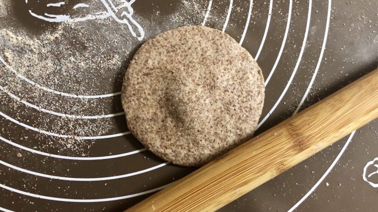 黑全麦豆沙包,把圆面团按扁，擀成中间厚四周薄的圆片