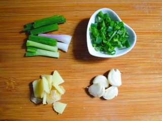 排骨烧山药 （电饭煲版）,将葱切成葱段，并将葱叶切成少许的葱花。将姜切成片，蒜用刀压扁。