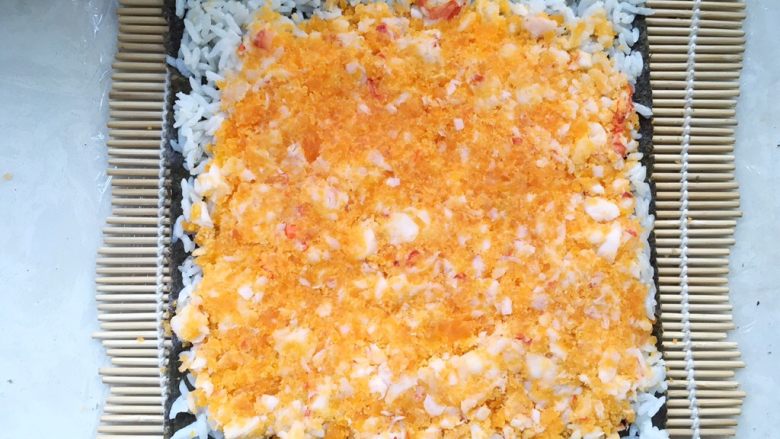 咸蛋黄红虾寿司,取一半咸蛋黄虾肉，均匀的铺在米饭上，并压平整
