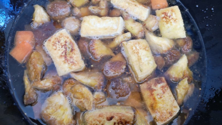 红烧猴头菇,锅中留点底油，放入胡萝卜片和姜末翻炒几下后加入炸好的猴头菇和豆腐，再加入清水