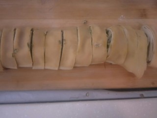 豆腐皮包荠菜肉末卷,放到砧板上。切段