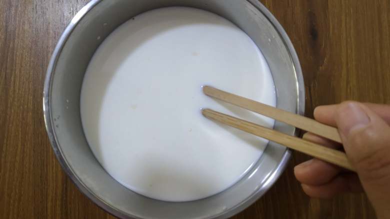 自制烤箱版酸奶,用消过毒的筷子将牛奶和酸奶菌搅拌均匀。