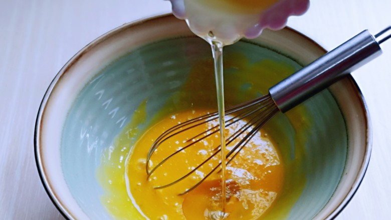 红丝绒草莓奶油蛋糕卷～下午茶必备甜品,先做蛋黄糊，蛋黄用手动打蛋器打散，加入<a style='color:red;display:inline-block;' href='/shicai/ 140122'>玉米油</a>，使油和蛋液完全融合再一起，(色拉油也可以，但是一定要无味的)不建议使用黄油或橄榄油。