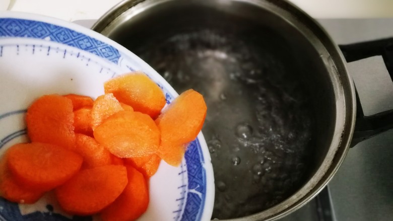 酸甜西兰花鸡丝,锅中水开，放入3克盐，1克食用油，放入胡萝卜烧开