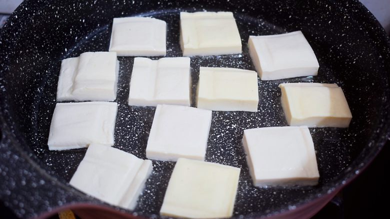 香煎豆腐,平底锅倒入适量的食用油烧热，放入豆腐