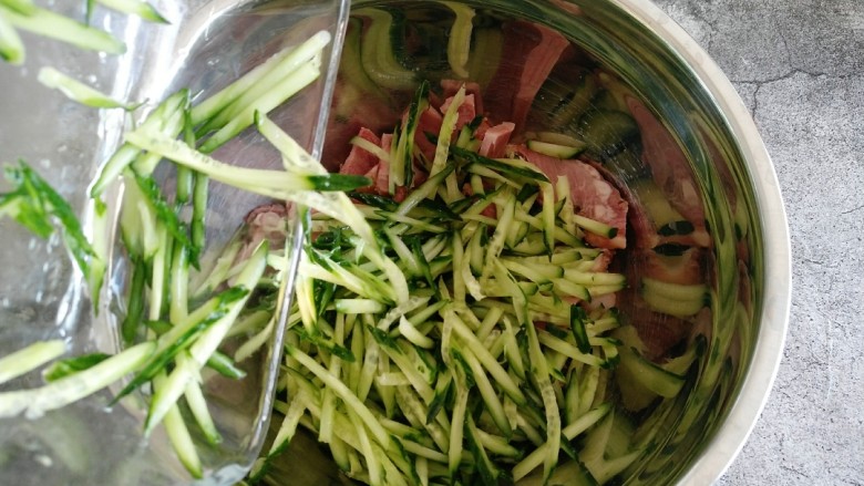 凉拌猪头肉,把擦好的黄瓜丝倒入猪头里。