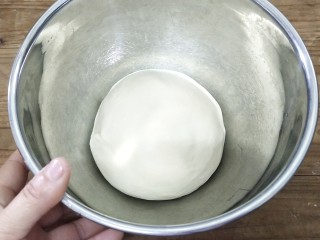 牛奶吐司,手沾黄油，把面团滚圆，放入发酵盆里