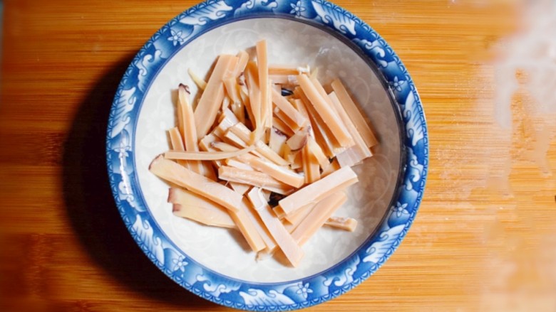 青椒胡萝卜炒鱿鱼,将泡好的鱿鱼洗干净后切成条形备用。