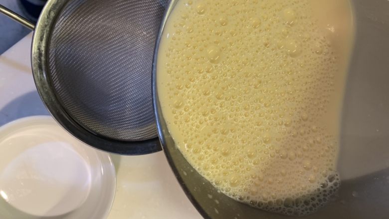 奶香焦糖布丁,用网过滤器，分配搅拌好的蛋液至烤碗中