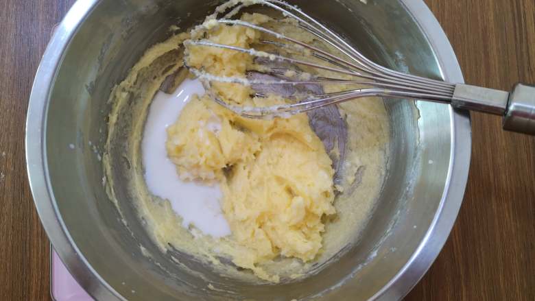 脆脆的奶香椰蓉球,牛奶也分两次加入黄油中，搅拌均匀。