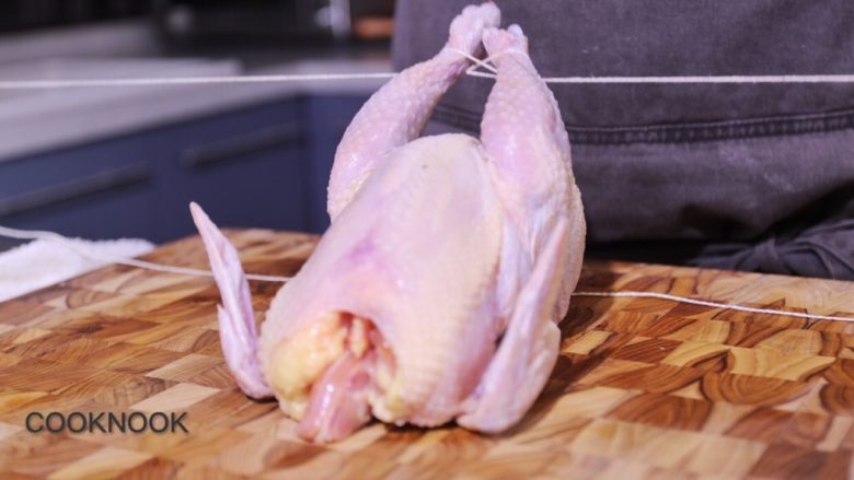 烤春鸡,把腿骨用厨用麻绳绑起, 绕过鸡翅, 绑在鸡脖骨上.