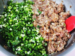 翠玉猪肉韭菜饺子,把肉馅搅拌均匀后，放入提前切碎的韭菜。