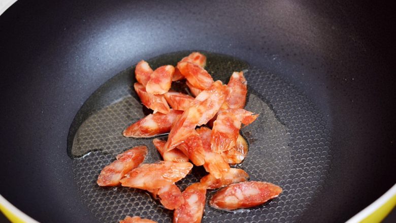 腊肠炒青椒,锅中倒入适量的食用油烧热，放入腊肠翻炒至变色
