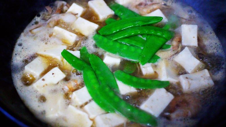 六鲜菌菇海鲜豆腐什锦汤,大火煮沸后，放入提前焯水的荷兰豆。
