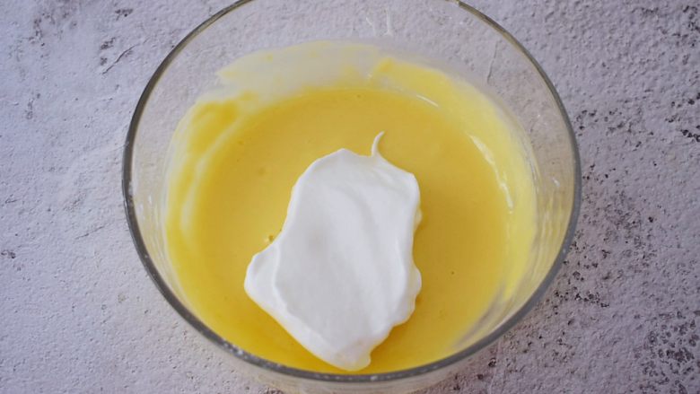 舒芙蕾松饼,把三分之一的蛋白霜放入蛋黄中翻拌均匀