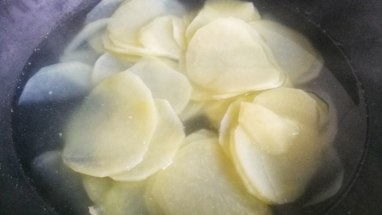 爽口酸辣土豆片,土豆片放入锅中滚水煮熟后捞出。