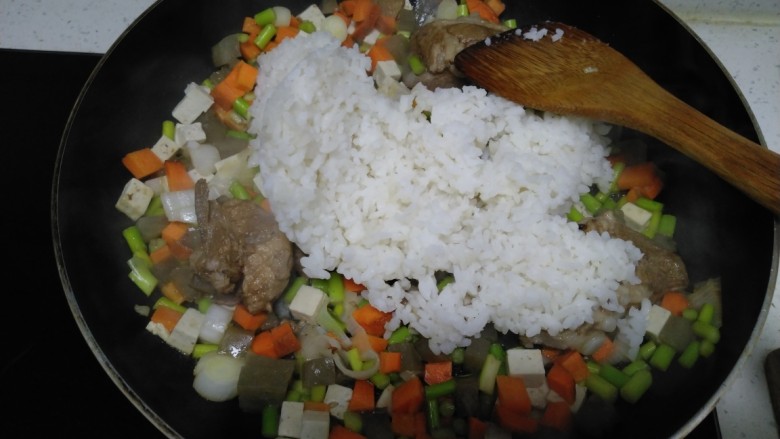 豆腐皮扎排骨炒米,炒至蒜苔、胡萝卜断生，倒入大米。
