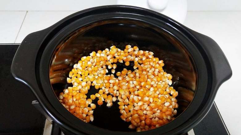 砂锅爆米花,翻炒，让每颗玉米粒都沾满油，继续中火不停翻炒，让玉米粒受热均匀。