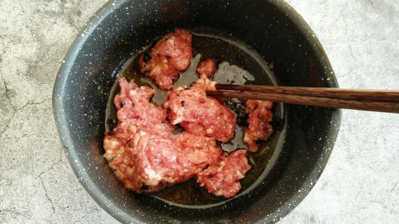 酸菜猪肉饺子,待油温稍微冷却后 倒入豆豉及剁好的肉馅 顺时针搅拌均匀。