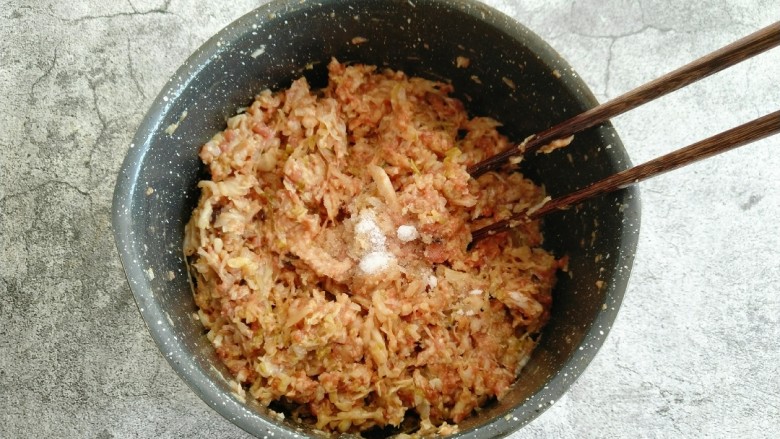 酸菜猪肉饺子,加入食盐 继续顺时针搅拌均匀即可 搅拌好后可以稍微尝一下咸淡 再决定盐的用量。