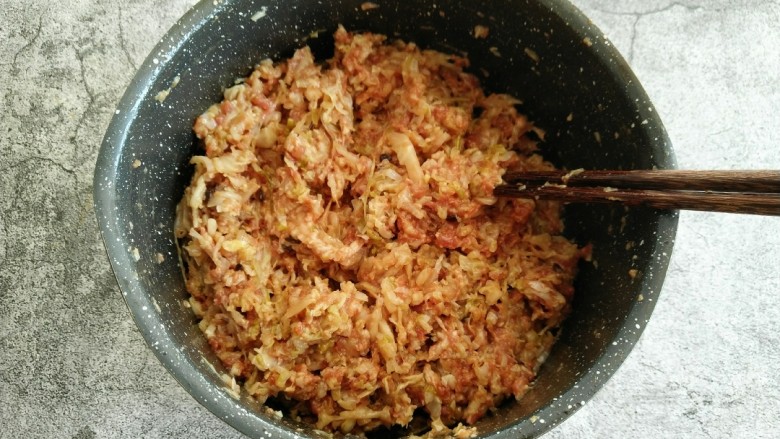 酸菜猪肉饺子,倒入提前剁好的酸菜 继续顺时针搅拌均匀。