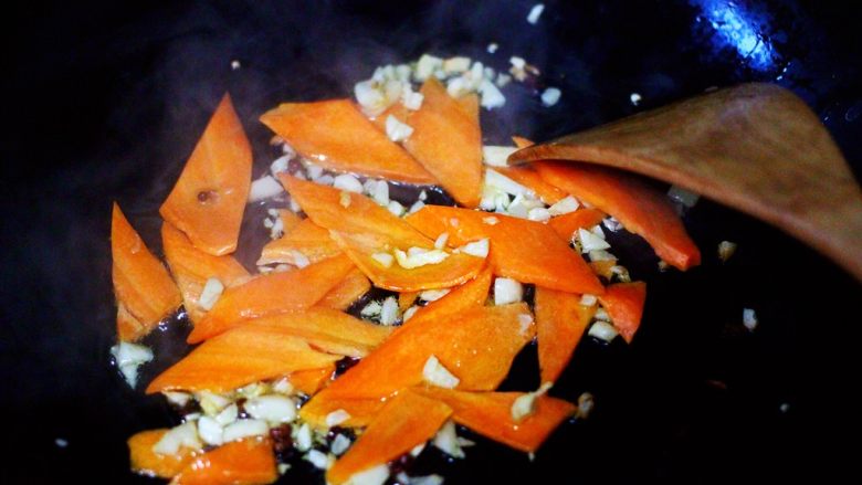 荷兰豆海鲜豆芽小炒,这个时候加入胡萝卜片，放到锅里小火慢慢煸炒。