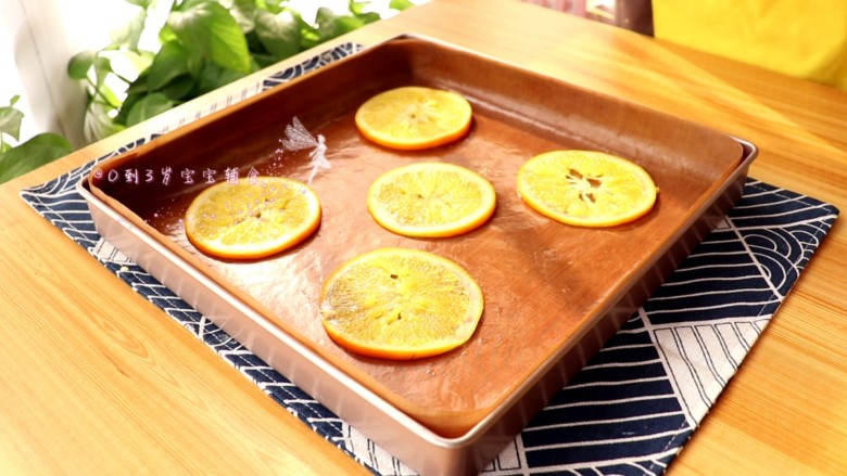 宝宝辅食 香橙蛋糕卷,橙片放在铺烤垫的烤盘上，倒入翻拌均匀的蛋糕糊