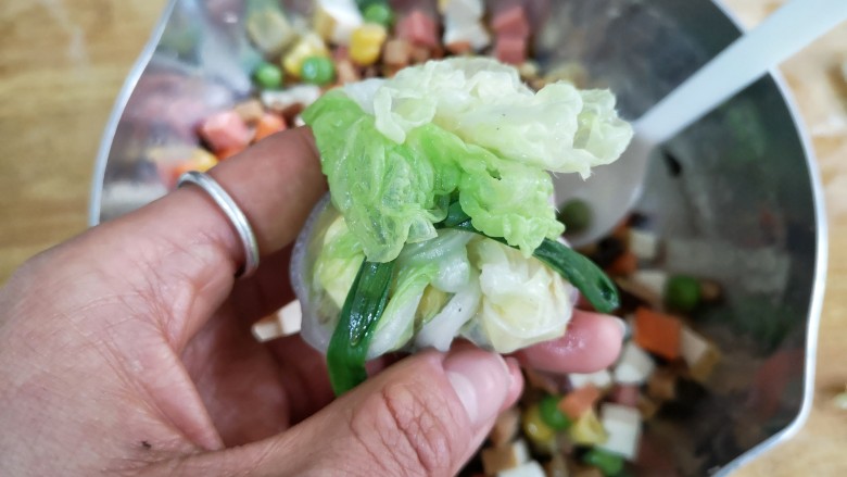 八宝百财福袋,将一圈的菜叶收起来，用韭菜缠绕后打结。