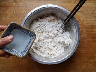 八宝百财蒸饺,在面粉中加一点点盐（也可以直接用饺子粉），少量多次加入温水，用筷子搅拌成雪花状。