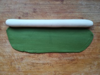 八宝百财蒸饺,把白色面团搓成圆柱形长条，将绿面团擀成椭圆形。（白色面团和绿色面团用量为2:1即可）