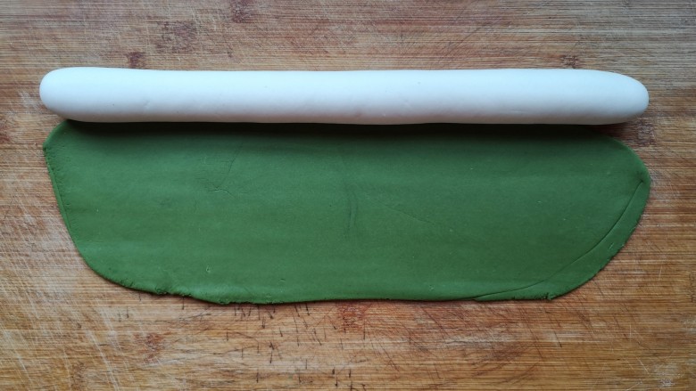 八宝百财蒸饺,把白色面团搓成圆柱形长条，将绿面团擀成椭圆形。（白色面团和绿色面团用量为2:1即可）