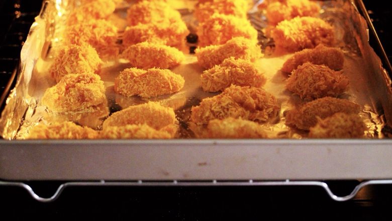 少油减脂的劲爆鸡米花,烤箱提前预热后，把烤盘入烤箱的中层。
