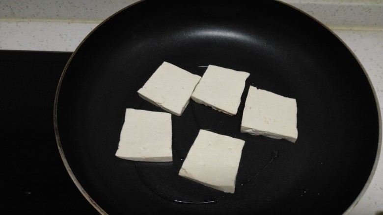 豆腐排骨炒白菜,不粘锅中放入少许油，放入豆腐。