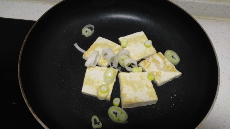 豆腐排骨炒白菜,放入葱碎炒香。