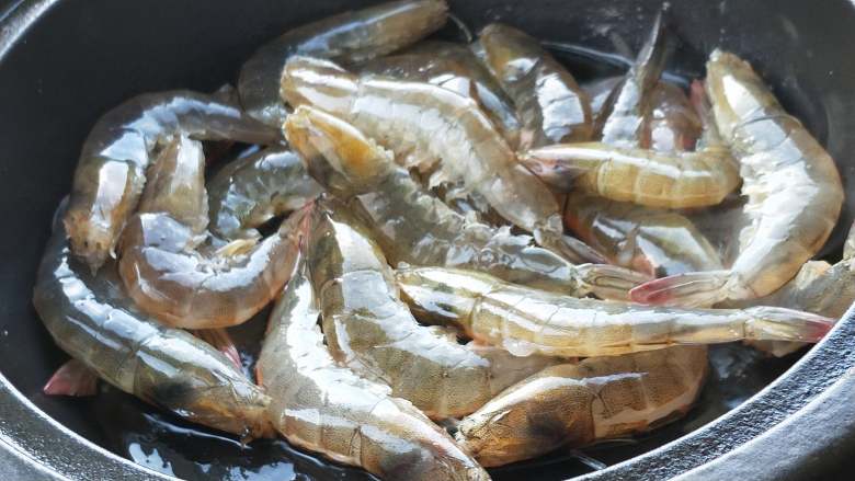 年夜饭之油焖大虾,塔吉锅烧热加油，油烧热放入大虾。