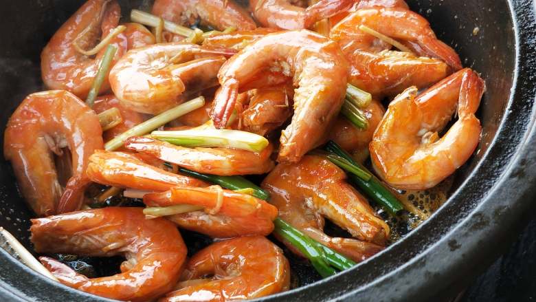 年夜饭之油焖大虾,葱姜炒出香味后倒入碗汁。
