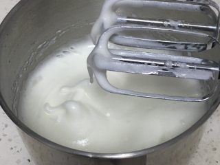 烹调奶油咖啡蛋糕,蛋白出现下垂的弯钩，加入15克细砂糖，继续搅打50圈。
