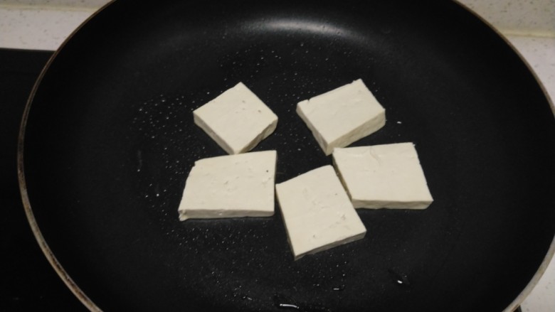 豆腐猪皮炒西葫芦,不粘锅中放入适量油，放入豆腐。