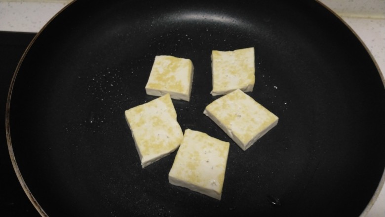豆腐猪皮炒西葫芦,煎至一面金黄，翻面。