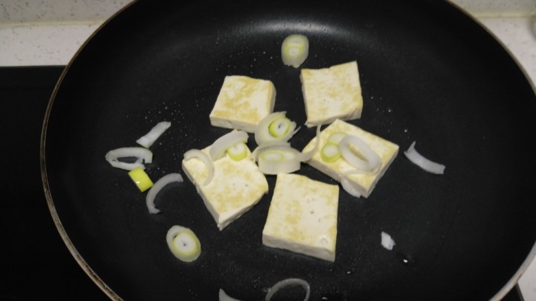 豆腐猪皮炒西葫芦,煎至两面金黄，撒入葱碎。