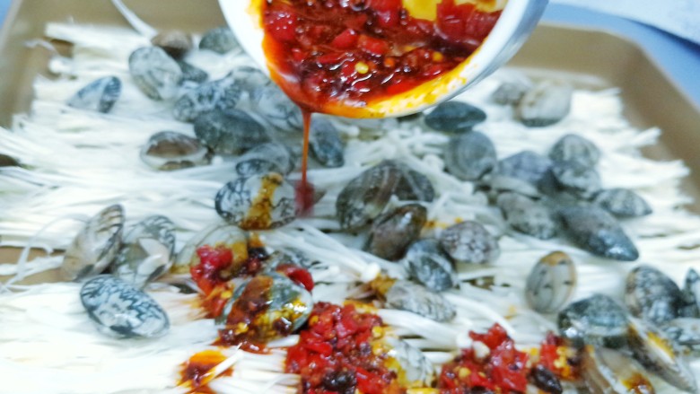 烤箱版【金针菇蒜香烤花蛤】,把调汁淋到花蛤上面。