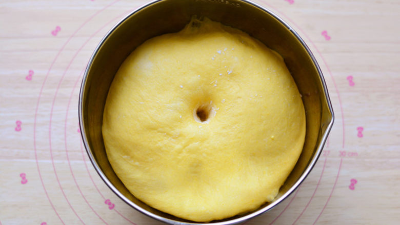南瓜排包,揉好的面团，放在盆中盖保鲜膜进行基础发酵，面团发酵到1.5-2倍大，手指沾面粉戳一个洞，不回缩、不塌陷，发酵完成。