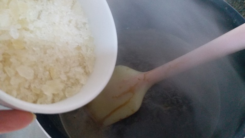 自制阿胶糕,泡软的阿胶连同黄酒一起倒进不粘锅小火熬制。煮开后加入冰糖继续小火熬，期间不停地搅拌。