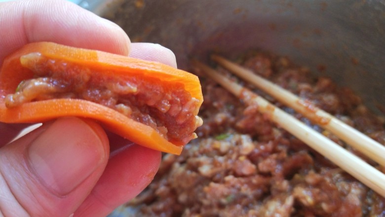 新文美食  青红萝卜蒸肉末,胡萝卜片放入肉馅折叠。